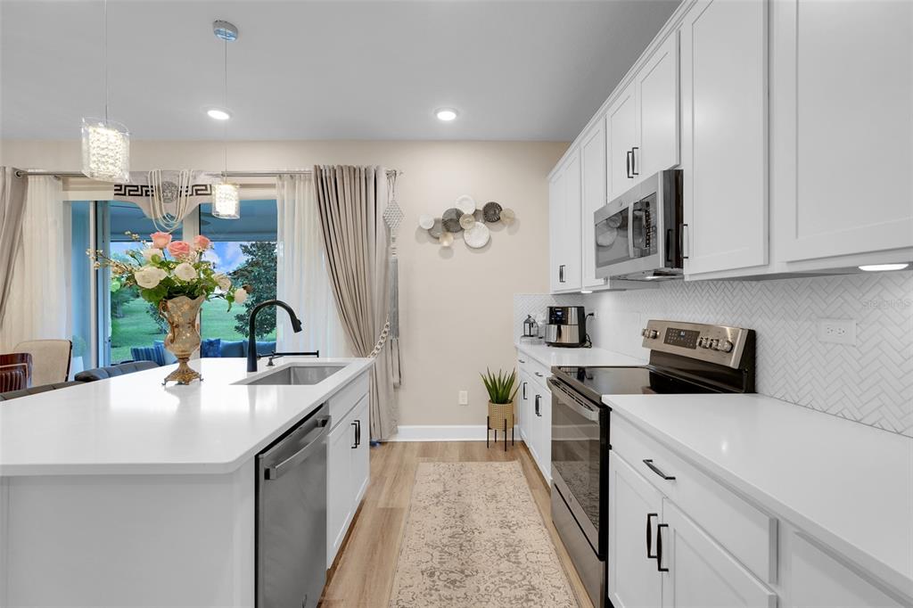 10169 Spring Lake Drive Clermont, FL 34711 - Photo 15 of 54 a kitchen with kitchen island granite countertop a sink stove and refrigerator