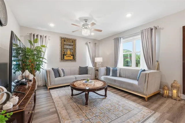 a living room with furniture chandelier and a window