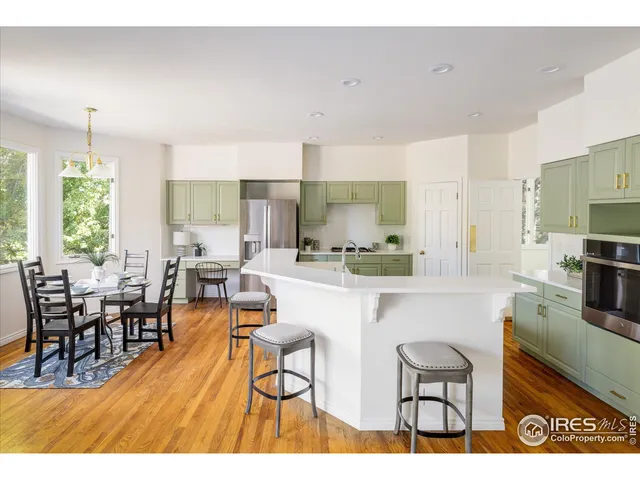 a kitchen with stainless steel appliances wooden floor dining table and chairs