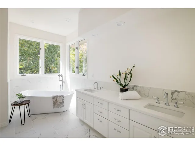 a spacious bathroom with a double vanity sink a mirror and a bathtub