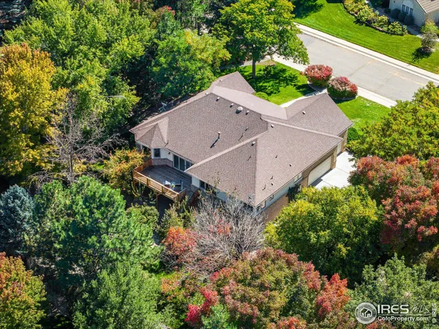 an aerial view of residential houses with outdoor space and trees