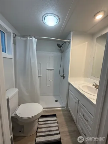 a bathroom with a sink a toilet and shower