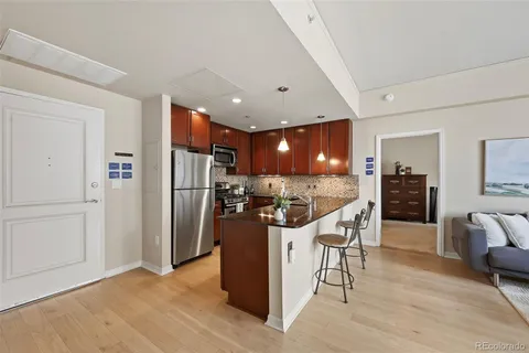 a living room with furniture and view of kitchen