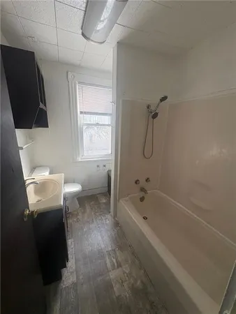 a spacious bathroom with a granite countertop sink a toilet and bathtub