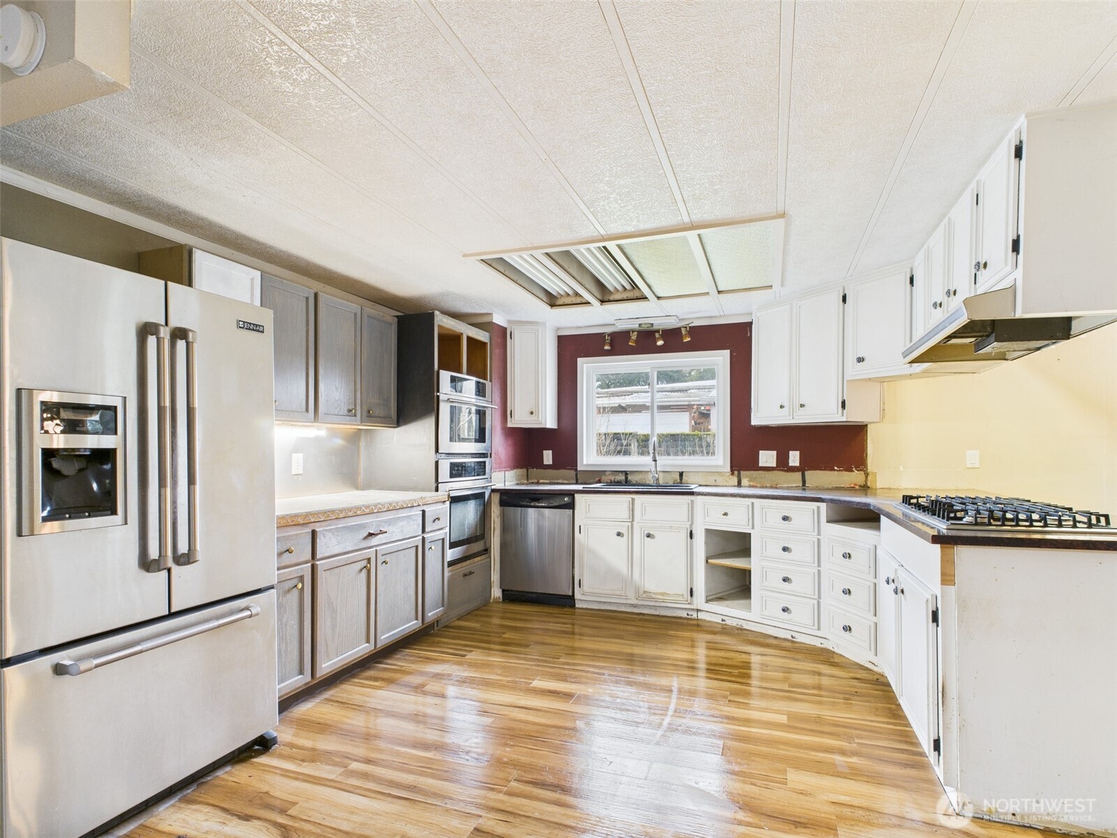 201 Union Avenue Southeast, Unit 183 Renton, WA 98059 - Photo 8 of 30 a white kitchen with granite countertop a stove top oven a sink a refrigerator and white cabinets