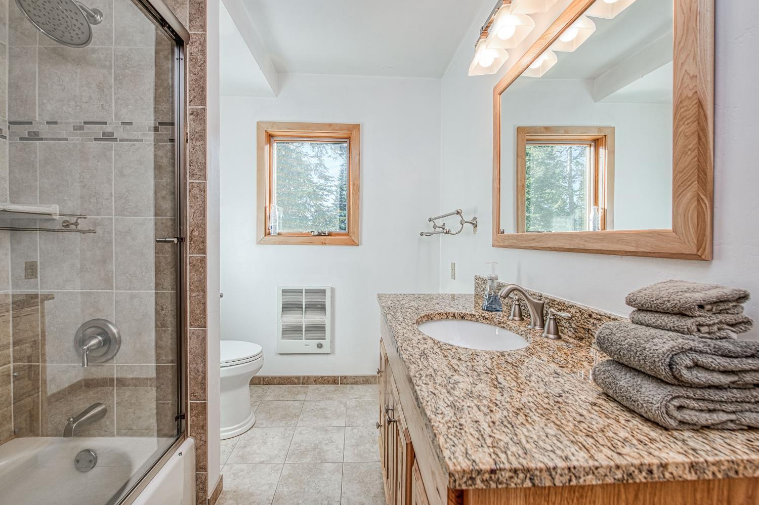 55578 Cordwood Road Shaver Lake, CA 93664 - Photo 19 of 59 a bath room with a granite countertop tub sink and mirror
