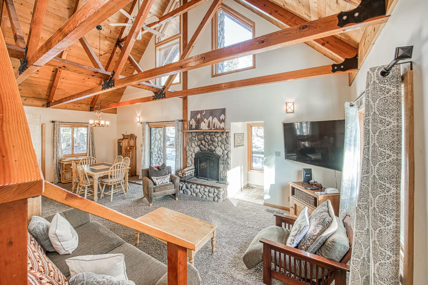 55578 Cordwood Road Shaver Lake, CA 93664 - Photo 22 of 59 a living room with furniture a flat screen tv and floor to ceiling window