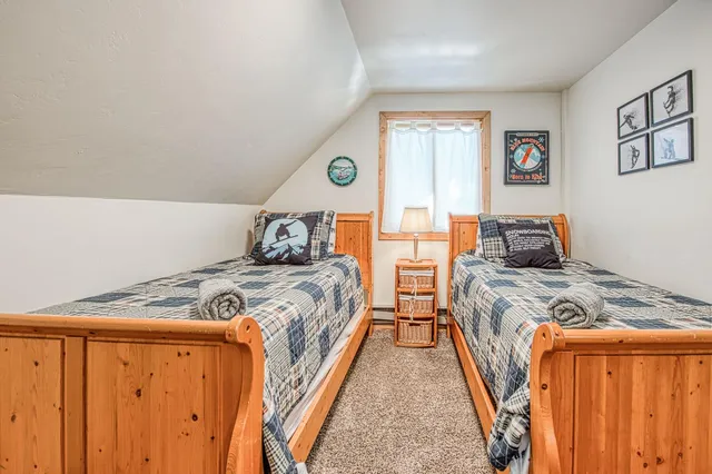 a bedroom with a bed and a lamp on dresser