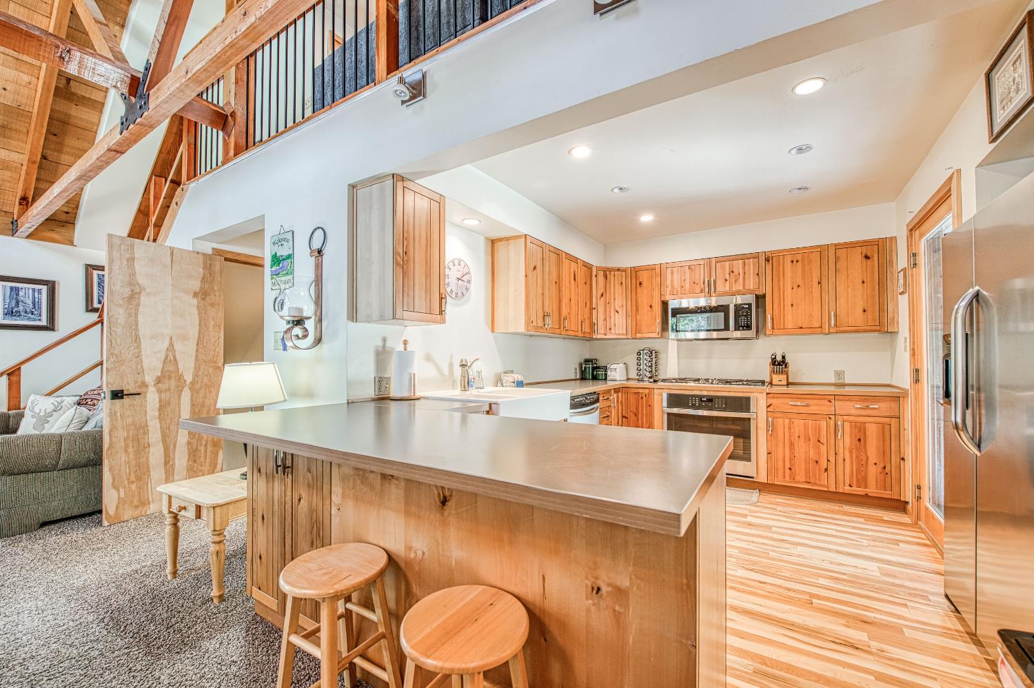55578 Cordwood Road Shaver Lake, CA 93664 - Photo 6 of 59 a large kitchen with stainless steel appliances kitchen island granite countertop a sink and cabinets