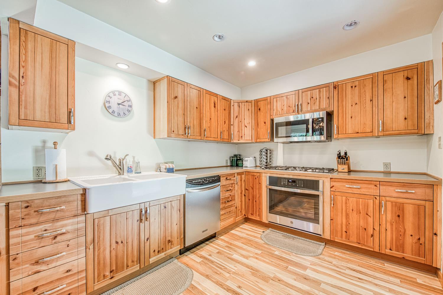 55578 Cordwood Road Shaver Lake, CA 93664 - Photo 7 of 59 a kitchen with stainless steel appliances granite countertop a stove top oven a sink dishwasher and white cabinets with wooden floor