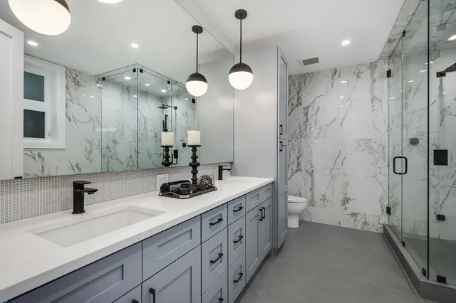 a bathroom with a double vanity sink mirror and shower