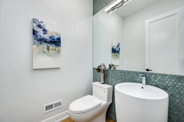 a bathroom with a toilet a sink and mirror