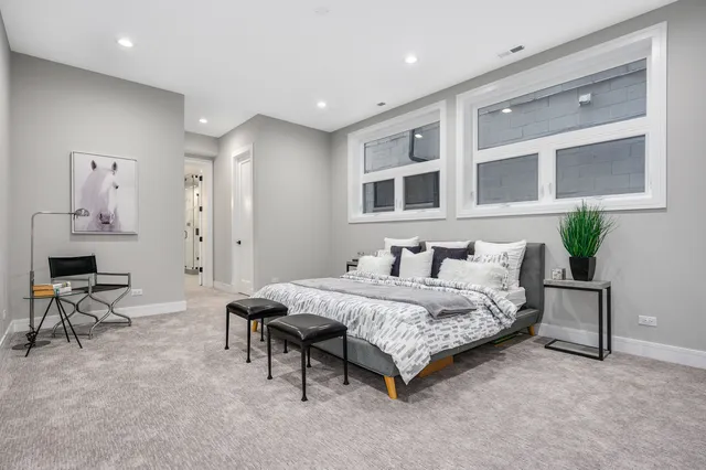 a spacious bedroom with a bed a table and chair