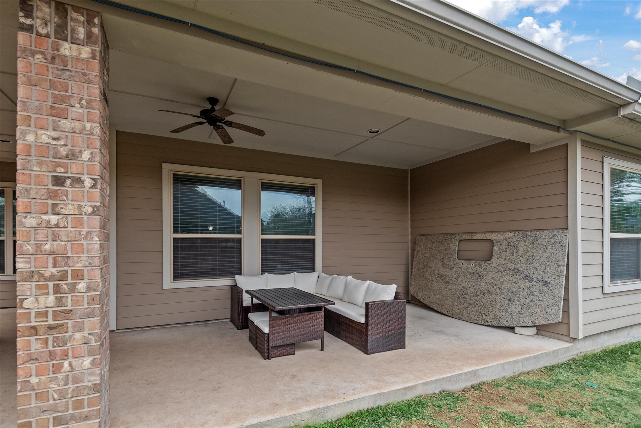31563 Ember Trail Lane Spring, TX 77386 - Photo 32 of 39 This inviting back porch features two large entertainment areas, perfect for hosting gatherings or enjoying quiet outdoor moments. One area is ideal for dining, with plenty of space for a large table and seating, while the other offers a cozy lounge space for relaxation, complete with comfortable seating and an ideal spot for a fire pit or outdoor TV.