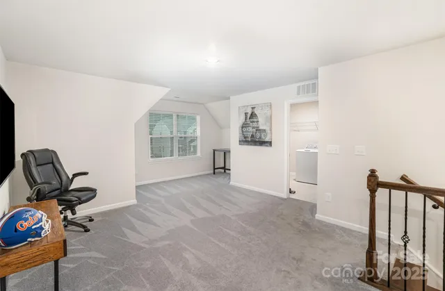 a view of a workspace with furniture and a window