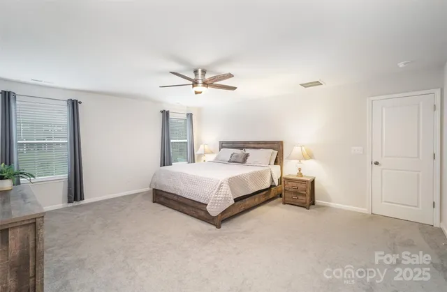 a bedroom with a large bed and a chandelier