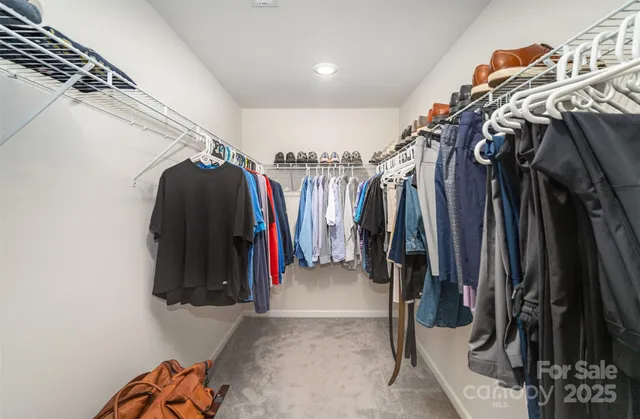 a view of walk in closet with clothes