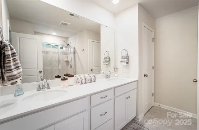 a bathroom with double sink and a mirror