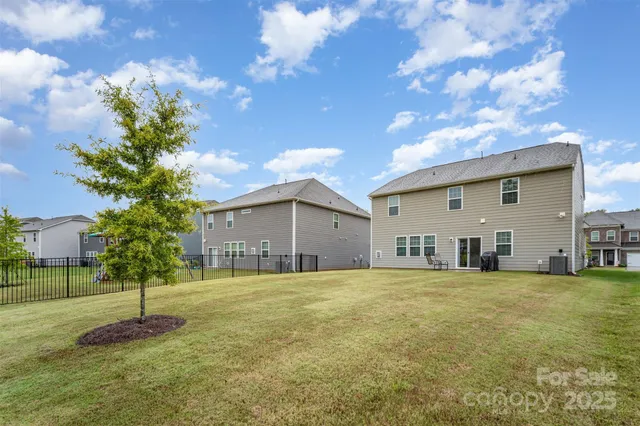 a view of a house with a big yard and large trees