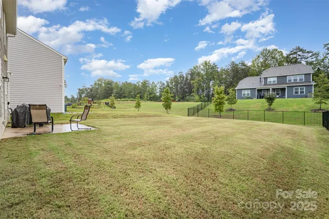 a view of an house with backyard and a tree