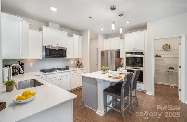 a kitchen with a dining table chairs and stove top oven