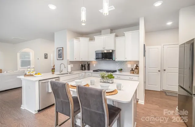 a kitchen with a dining table chairs refrigerator and cabinets