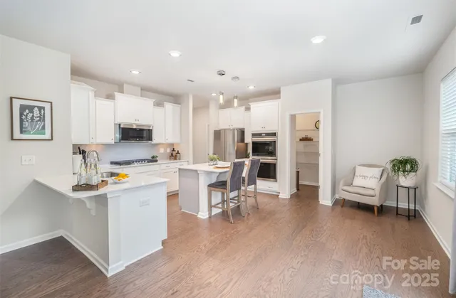 a kitchen with stainless steel appliances kitchen island granite countertop a sink and cabinets