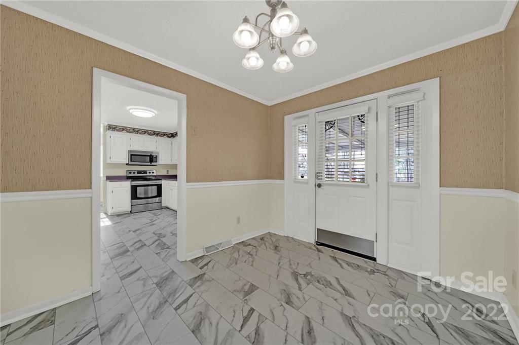 311 Maple Street, Unit 7 Union, SC 29379 - Photo 11 of 34 an empty room with wooden floor cabinet and windows