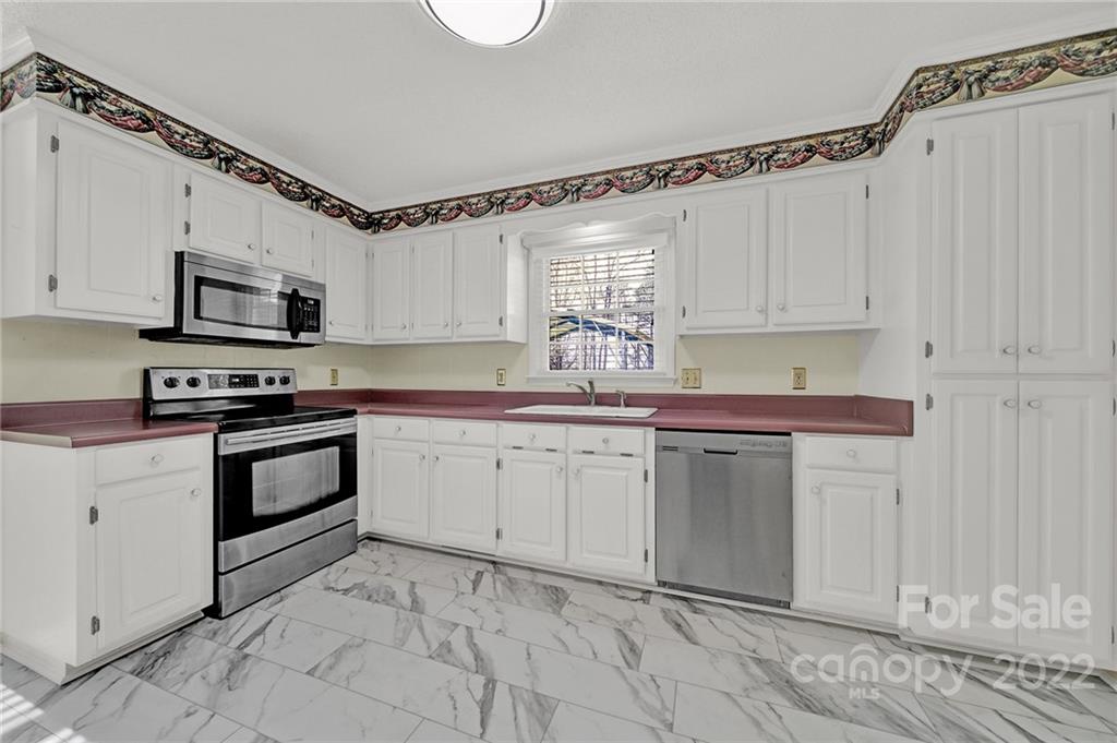 311 Maple Street, Unit 7 Union, SC 29379 - Photo 15 of 34 a kitchen with granite countertop a sink cabinets stainless steel appliances and a window