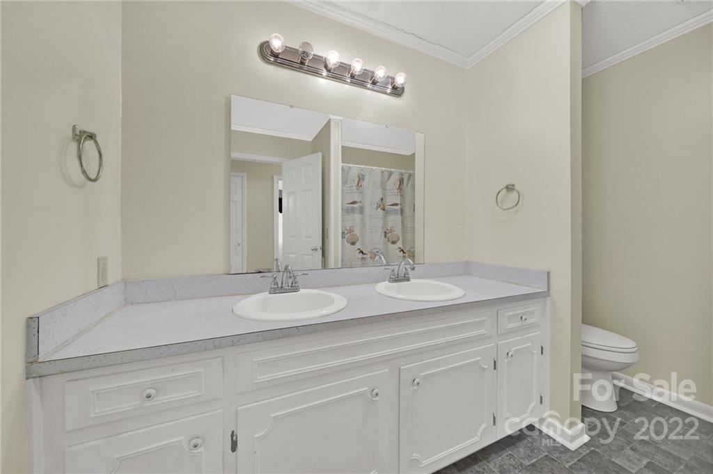 311 Maple Street, Unit 7 Union, SC 29379 - Photo 20 of 34 a bathroom with a granite countertop sink a toilet and a mirror