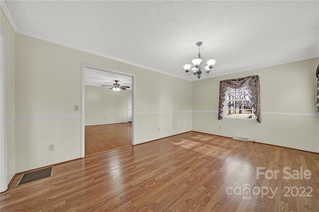 311 Maple Street, Unit 7 Union, SC 29379 - Photo 9 of 34 wooden floor in an empty room with a chandelier