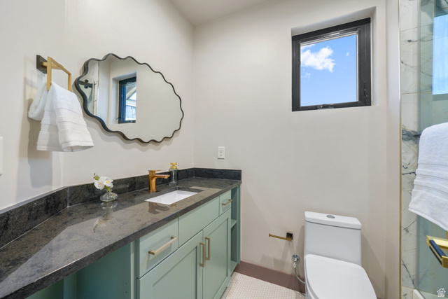 10646 North Reflection Ridge Hideout, UT 84036 - Photo 21 of 43 Bathroom featuring a mint green vanity with a dark countertop, an undermount sink with a gold-tone faucet, a decorative mirror, and a window with a black frame
