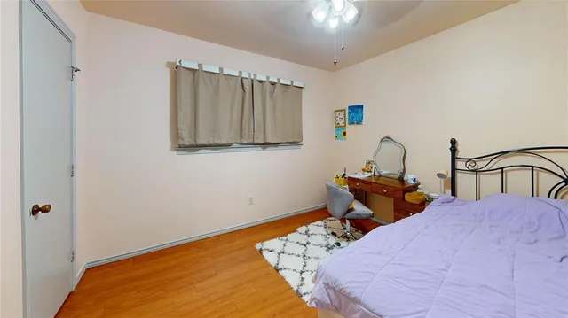 a room with a bed and wooden floor