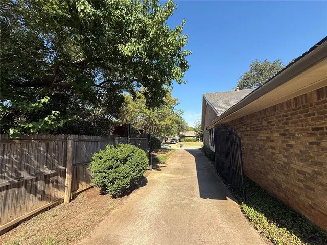 a view of backyard with potted plants and wooden fence