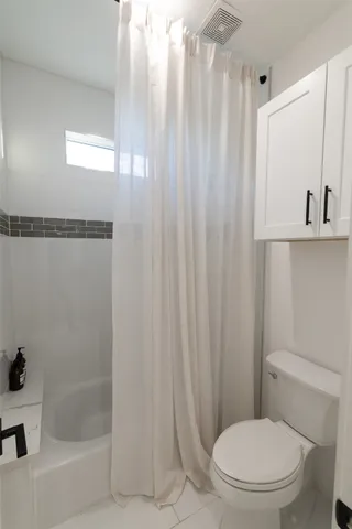 a bathroom with a toilet and a shower