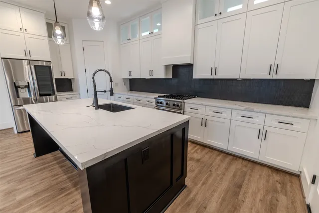 a kitchen with white cabinets appliances and wooden floor