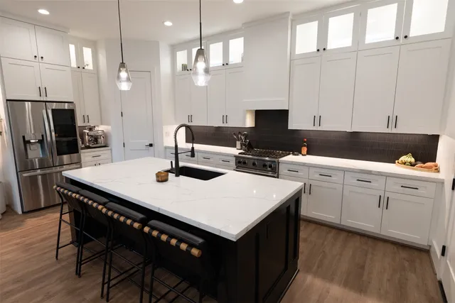 a kitchen with stainless steel appliances a table chairs and a refrigerator