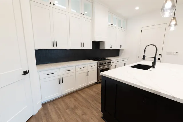 a kitchen with a sink a stove and cabinets