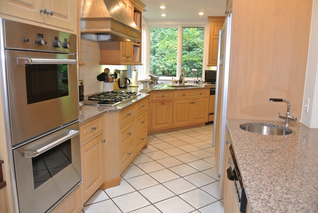 423 Concord Road Weston, MA 02493 - Photo 9 of 30 a kitchen with granite countertop white cabinets and white appliances