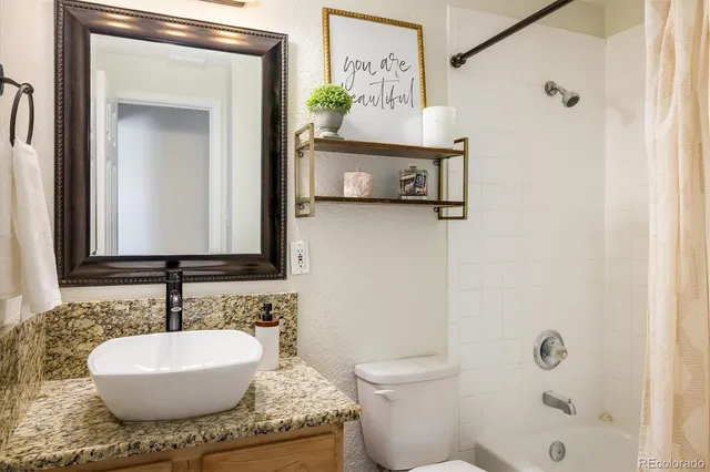 a bathroom with a granite countertop sink and a mirror