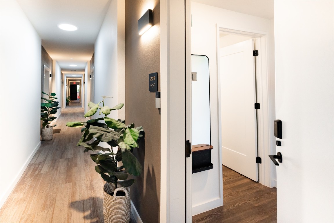 49 Navasota Street, Unit 209 Austin, TX 78702 - Photo 21 of 32 a view of a hallway with wooden floor and a glass door