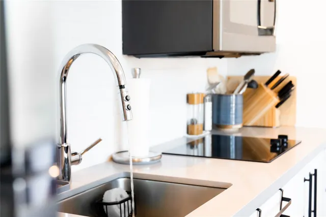 a kitchen with a sink and a stove with wooden floor