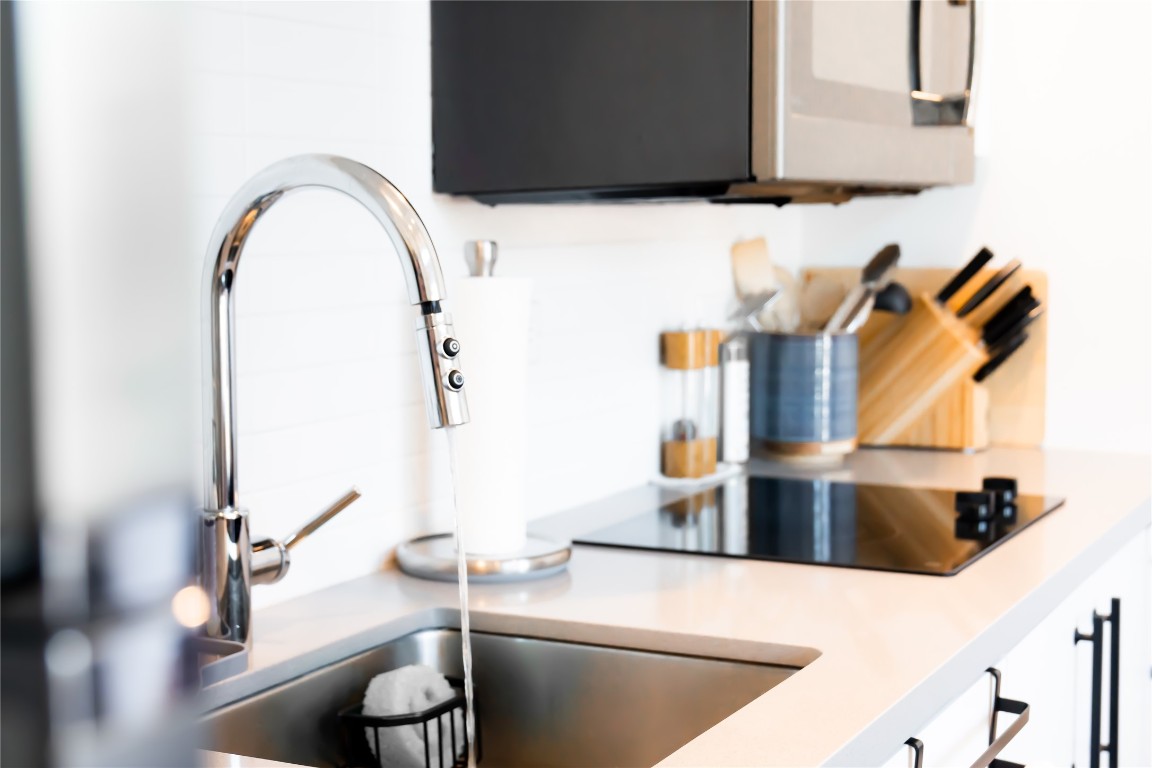 49 Navasota Street, Unit 209 Austin, TX 78702 - Photo 9 of 32 a kitchen with a sink and a stove with wooden floor