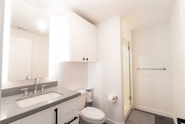 a bathroom with a granite countertop sink mirror vanity and toilet