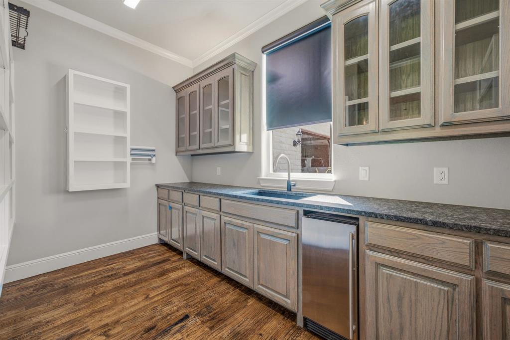 9503 Bellechase Road Granbury, TX 76049 - Photo 12 of 40 a kitchen with granite countertop wooden cabinets and a sink