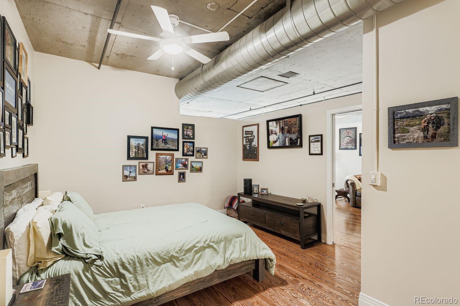 1499 Blake Street, Unit 4G Denver, CO 80202 - Photo 20 of 33 a bedroom with a bed and wooden floor