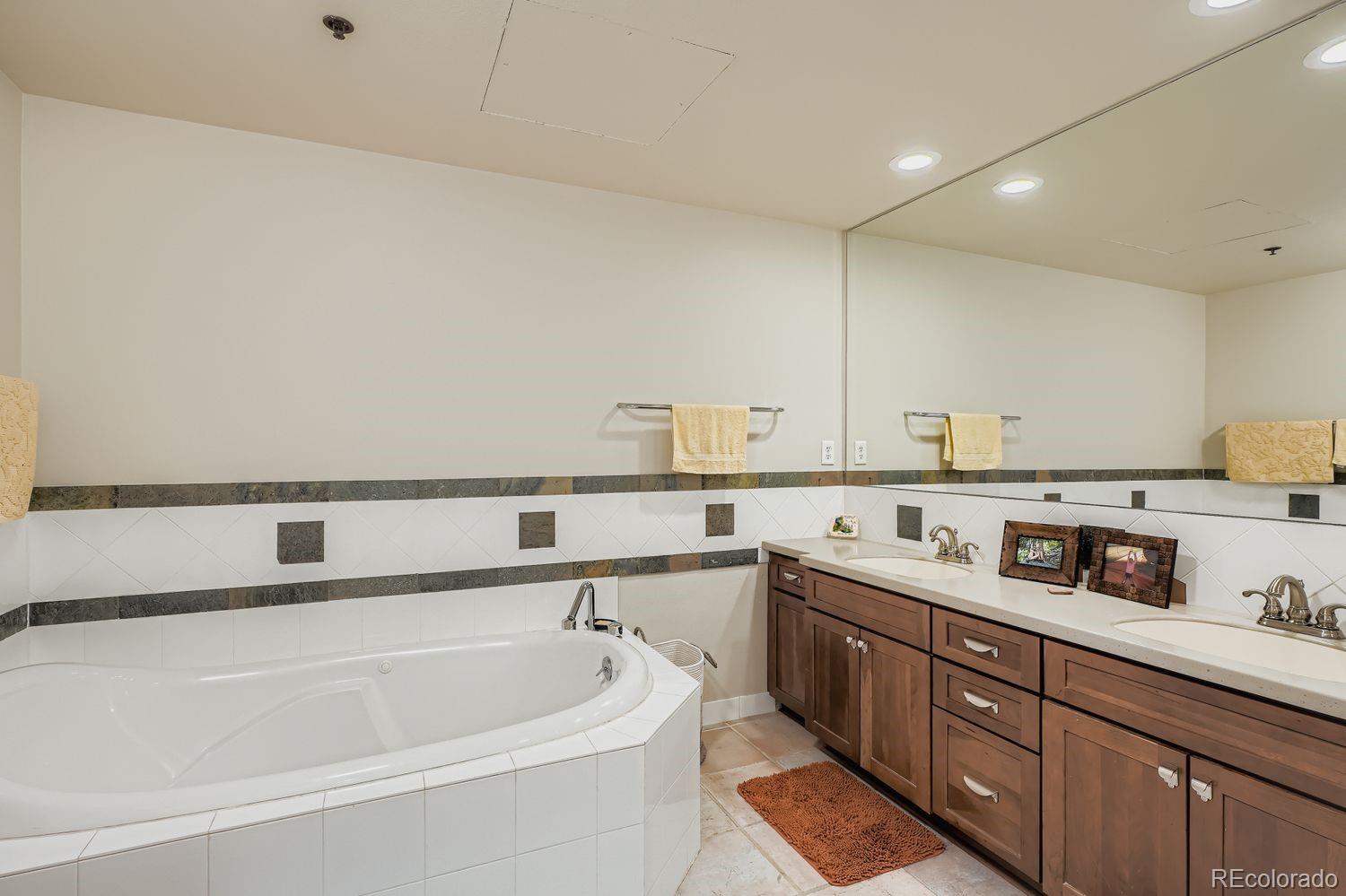 1499 Blake Street, Unit 4G Denver, CO 80202 - Photo 22 of 33 a bathroom with a tub sink and mirror