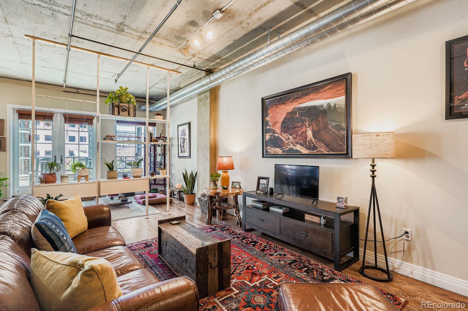1499 Blake Street, Unit 4G Denver, CO 80202 - Photo 5 of 33 a living room with furniture a flat screen tv and a fireplace