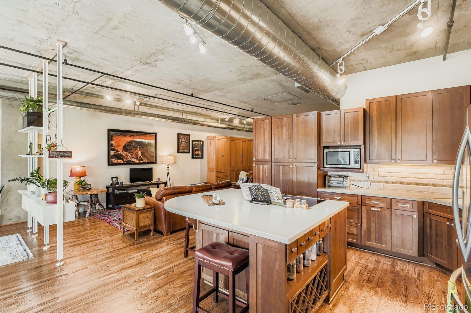 1499 Blake Street, Unit 4G Denver, CO 80202 - Photo 8 of 33 an open kitchen with a sink and chairs