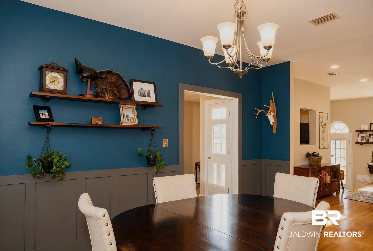 8008 Patricks Landing Road Bay Minette, AL 36507 - Photo 8 of 33 Dining area featuring wainscoting, decorative wall shelving, a multi-light chandelier, and wood-finish flooring